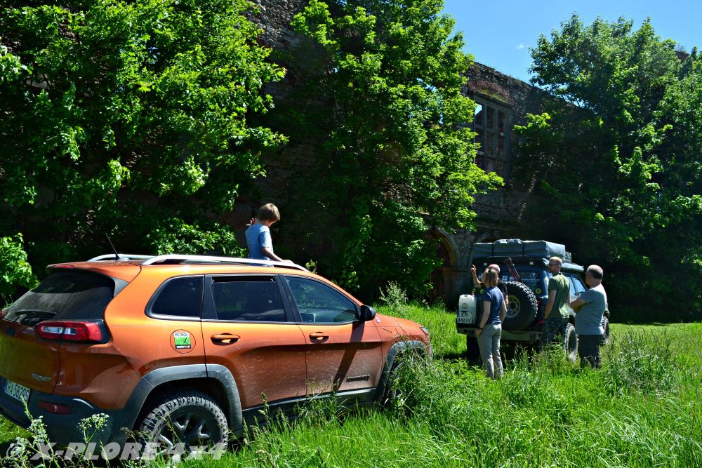 auta terenowe przed ruinami pałacu